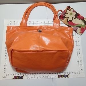 New. Stunning vibrant orange bag with floral lining. Matching wrist wallet .